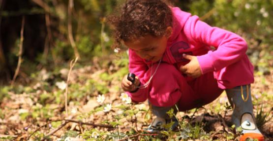Fillette observant les feuilles avec une loupe